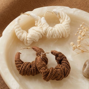 Puede incluir: Un juego de tres tazas de cerámica con un acabado mate moteado. Las tazas son de color crema, gris claro y gris oscuro. Cada taza tiene un diseño simple y minimalista y un asa redondeada.