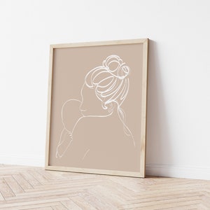 Peut inclure: Une impression d'art en ligne d'une femme tenant un enfant dans un cadre. L'impression est sur un fond beige avec un cadre blanc.