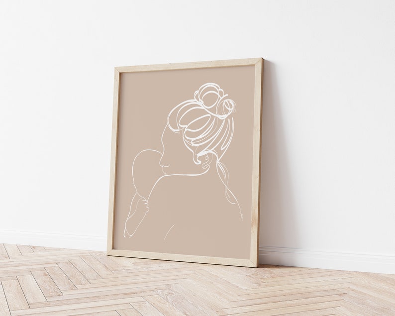 Peut inclure: Une impression d'art en ligne d'une femme tenant un enfant dans un cadre. L'impression est sur un fond beige avec un cadre blanc.