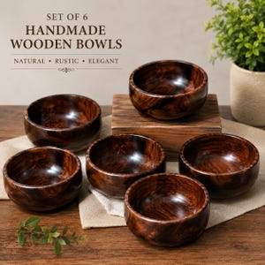May include: A set of six dark brown wooden bowls with visible wood grain patterns. The text on the image reads: SET OF 6 HANDMADE WOODEN BOWLS NATURAL • RUSTIC • ELEGANT. The bowls are arranged on a light-colored fabric surface.