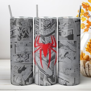 Puede incluir: Un vaso cil&iacute;ndrico de acero inoxidable con un estampado de c&oacute;mic en blanco y negro que muestra varias escenas de acci&oacute;n y un gran emblema de ara&ntilde;a roja prominente centrado en el frente. El vaso incluye una pajita negra fina en la parte superior.