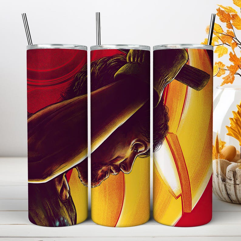 May include: A cylindrical stainless steel tumbler featuring a wrap-around graphic illustration of a person with dark hair holding a large hammer. The design uses a vibrant color palette of deep red, bright yellow, and orange tones with a metal straw.