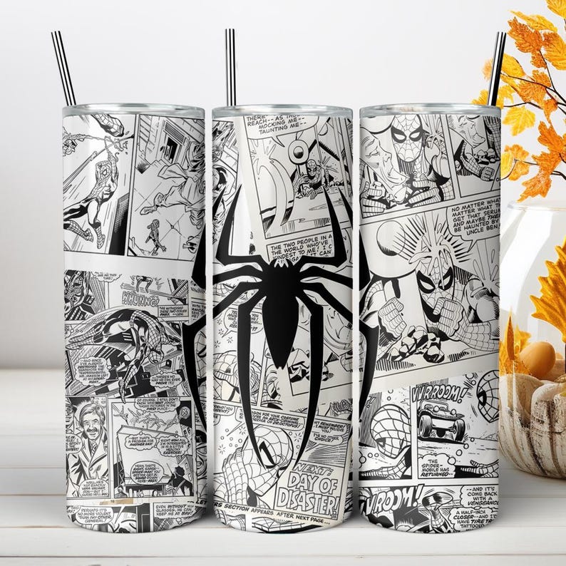 Puede incluir: Un vaso cil&iacute;ndrico de acero inoxidable con un estampado de c&oacute;mic en blanco y negro que muestra varias escenas de acci&oacute;n y un gran emblema de ara&ntilde;a negra. El vaso incluye una tapa transparente y una pajita negra fina en la parte superior.