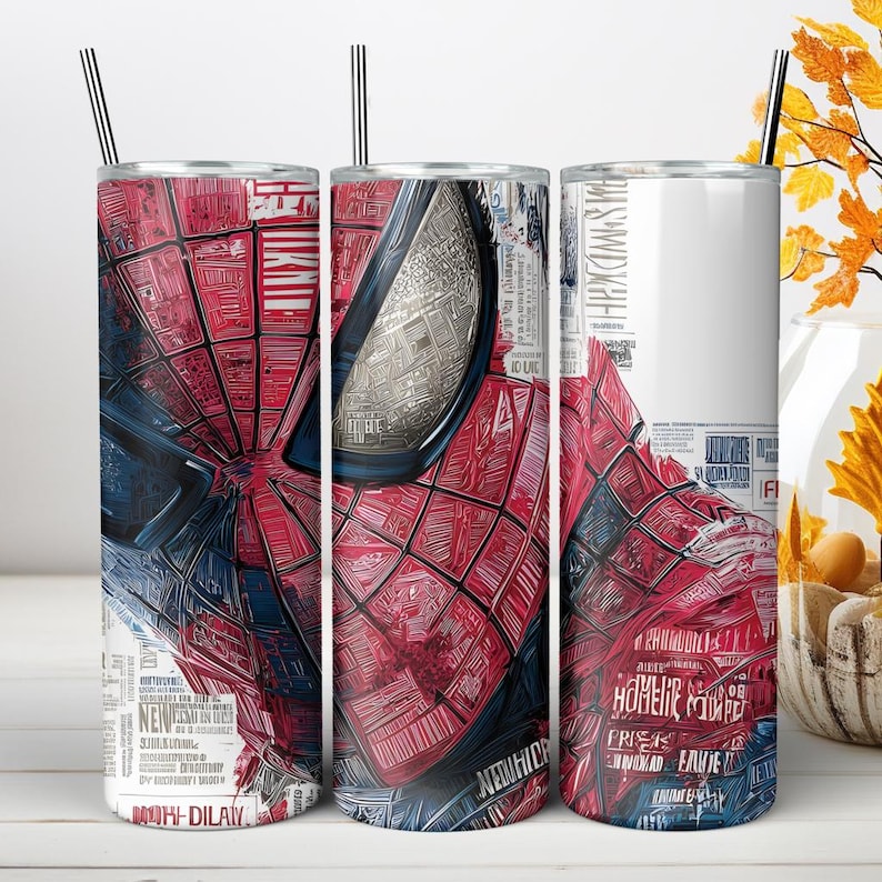 Puede incluir: Tres vasos cil&iacute;ndricos con pajitas de metal que presentan un estampado gr&aacute;fico de una m&aacute;scara de superh&eacute;roe roja y azul con un patr&oacute;n de telara&ntilde;a. El dise&ntilde;o incorpora superposiciones de texto estilo peri&oacute;dico y est&eacute;tica de c&oacute;mic.