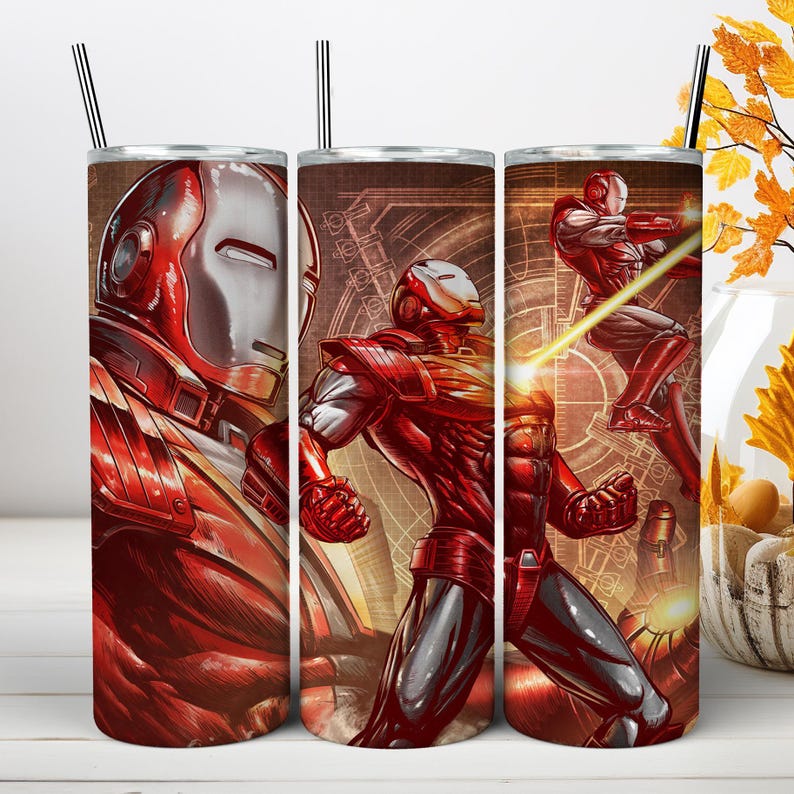 May include: A cylindrical stainless steel tumbler featuring a graphic print of a red and silver armored character in various action poses. The design includes technical line drawings in the background and a metallic straw inserted at the top.