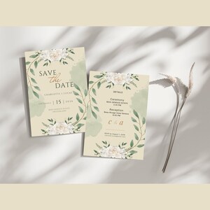 Pode incluir: Dois cart&otilde;es de convite de casamento com desenhos florais e de folhas. Os cart&otilde;es t&ecirc;m o texto "Save the Date" e os detalhes do evento. O design inclui flores brancas e folhas verdes, com um fundo bege claro.