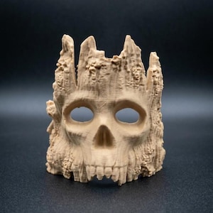 May include: A light tan, three-dimensional printed object shaped like a human skull integrated into a textured, tree-bark-like structure. The skull features hollow eye sockets and a nasal cavity, with the surrounding material mimicking rough wood grain.