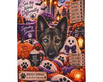 Op de afbeelding: Een rechthoekige fleece deken met een Duitse herder met één blauw en één bruin oog, omringd door pompoenen, een spookje, een mok met de tekst Good Dogs Brighter Days en teksten zoals See the World Differently en Hercules Approved.