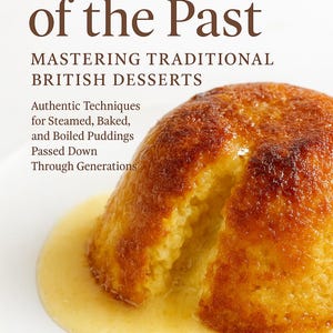 May include: A cookbook cover titled "Puddings of the Past" with a traditional British dessert on a white plate. The dessert is golden brown and served with a creamy sauce. The book's author is Priya Sharma.