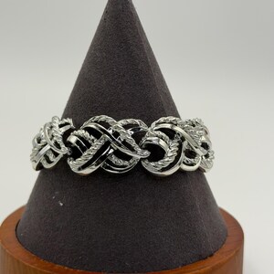 Bracelet vintage signé Panula, couleur argent, à maillons ornés.