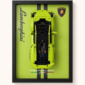 Op de afbeelding: Een ingelijste display met een limoengroene Lamborghini Huracan Tecnica modelauto van bovenaf gezien. De achtergrond is limoengroen met zwarte verticale strepen, het Lamborghini-logo en de tekst Lamborghini Huracan Tecnica erop gedrukt.