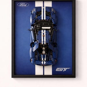 Peut inclure: Œuvre encadrée représentant une Ford GT bleue avec des bandes blanches. La voiture est placée sur un fond bleu, avec le logo Ford et l'emblème GT visibles. L'œuvre est encadrée dans un cadre noir.