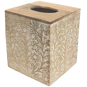 May include: A square wooden tissue box cover featuring a natural light brown finish with an intricate, carved floral pattern highlighted in white paint. The top surface includes a smooth, plain wooden border surrounding a central oval opening.