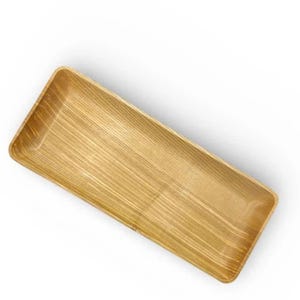 May include: A rectangular wooden tray with a light brown finish and a visible natural wood grain pattern. The tray features rounded corners and slightly sloped sides, creating a shallow basin shape with a smooth, polished surface texture.