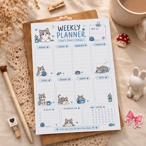 Puede incluir: Una hoja de planificador semanal con texto azul e ilustraciones de gatitos grises. El diseño incluye secciones para cada día de la semana, una lista de tareas, una sección de gratitud y un rastreador de hábitos con iconos de gatos.