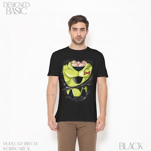 May include: Black t-shirt featuring a graphic design of a character's costume, with a torn effect revealing the design underneath. The design is primarily yellow and black, with a red bow. The text "DESIGNED BASIC" is at the top left.