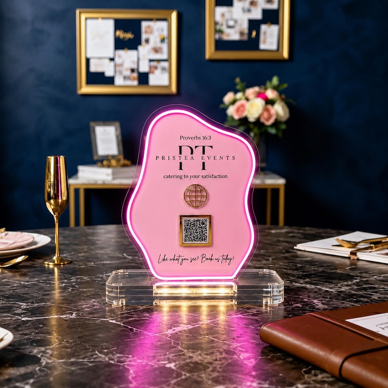May include: A pink, irregular-shaped acrylic sign with a glowing neon border, mounted on a clear rectangular base. It features the text 'Proverbs 16:3', 'PRISTEA EVENTS', 'catering to your satisfaction', a globe icon, a QR code, and 'Like what you see? Book us today!'