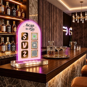 May include: An arched acrylic payment sign with a pink neon border and a clear base. The sign features the text "Scan to Pay" at the top, with three gold square icons on the left displaying currency symbols and three QR codes on the right side.
