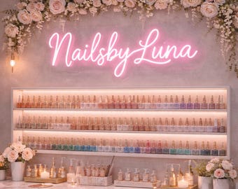 Puede incluir: Interior de un salón de manicura con un letrero de neón que dice "Nailsby Luna". Las paredes están decoradas con arreglos florales y estanterías que exhiben una amplia gama de colores de esmalte de uñas. La estética general es suave y femenina.
