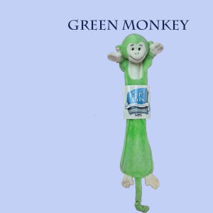 May include: A light green plush monkey bookmark with a white face and belly. The monkey has outstretched arms and a long tail. A white paper tag is attached to the center, featuring the blue text Page Pals and the Ganz logo at the bottom.