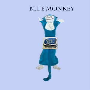 May include: A blue monkey plush toy with white hands, feet, and face. The monkey has a white chest patch and a long tail. A rectangular tag with the text "BLUE MONKEY" is positioned above the toy, and a smaller square label is on its midsection.
