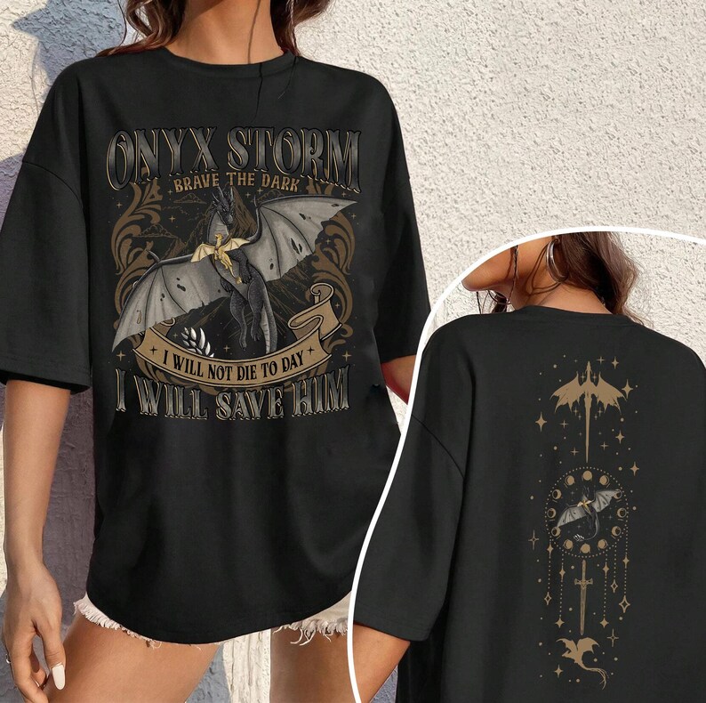 May include: Black t-shirt with a fantasy-themed graphic. The front features a dragon with text that reads "ONYX STORM BRAVE THE DARK" and "I WILL NOT DIE TO DAY I WILL SAVE HIM". The back has a matching design.