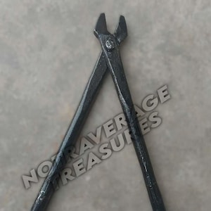 Puede incluir: Tenazas de herrero de metal negro, una herramienta para recortar y dar forma a las pezuñas de los caballos. Las tenazas están cruzadas, con los bordes cortantes hacia arriba. La herramienta es de metal oscuro y está sobre un fondo neutro.