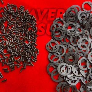 May include: An assortment of small, dark metal screws and circular washers with holes, arranged on a bright red surface. The image features a close-up view of the hardware components, suitable for various mechanical or construction projects.