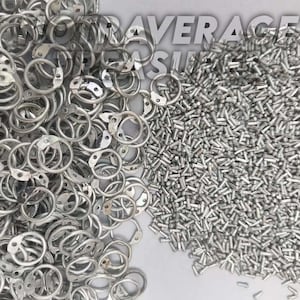 Puede incluir: Primer plano de una colección de anillos metálicos plateados con placas adjuntas y un montón de pequeños tornillos plateados. El texto "AVERAGE SUPPLY" es parcialmente visible en el fondo.