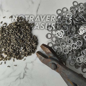 May include: A collection of small bronze-colored metal rivets and silver-colored metal jump rings arranged in two piles, accompanied by a pair of heavy-duty metal wire cutters. The text NOTRAVERSURE is visible in the center of the image.