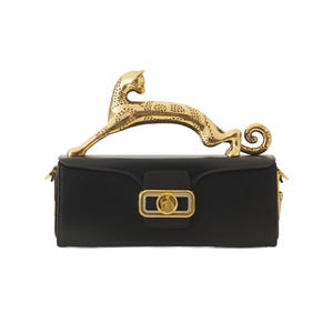Puede incluir: Un bolso de mano rectangular negro con un asa de metal dorado pulido en forma de leopardo saltando. La solapa frontal incluye un emblema central rectangular en dorado y plata con un diseño circular en relieve y herrajes dorados laterales.