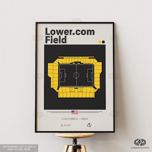 May include: A framed poster featuring a top-down view of Lower.com Field in Columbus, Ohio. The stadium is rendered in yellow against a black background, with a white border. The poster includes the text "Lower.com Field" and "COLUMBUS - OHIO".