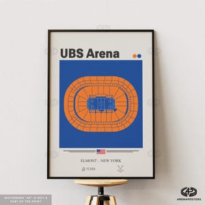 May include: Framed poster featuring a top-down view of UBS Arena in Elmont, New York. The arena is depicted in orange against a blue background. The poster includes the text "UBS Arena" and "Elmont - New York". The American flag is also visible.