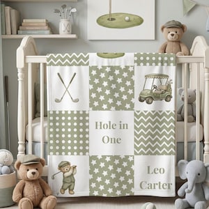 Puede incluir: Una manta de bebé de patchwork con patrones en verde salvia y blanco que incluyen estrellas, lunares y chevrones. El diseño presenta ilustraciones de palos de golf cruzados, un carrito de golf y un osito golfista, con el texto Hole in One y Leo Carter.