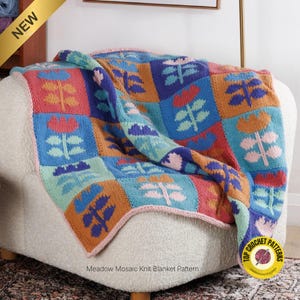 Peut inclure: Une couverture en tricot composée d'un quadrillage de carrés avec des motifs floraux en bleu, orange, rose et vert. La couverture présente une bordure rose clair et le texte Meadow Mosaic Knit Blanket Pattern. Le motif se compose de fleurs.