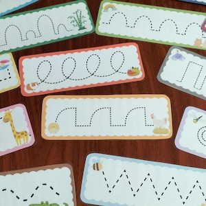 Puede incluir: Un conjunto de tarjetas de trazo coloridas con varios patrones de líneas punteadas. Cada tarjeta presenta un diseño diferente, incluyendo animales como un panda, una jirafa y una abeja, y bordes decorativos. Diseñadas para la educación infantil y el desarrollo de la motricidad fina.