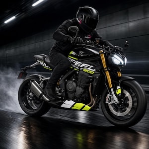 May include: A black Triumph Speed Triple 1200 motorcycle with yellow and white accents on the frame and tank. The motorcycle features gold front forks, a dual headlight assembly, and a silver exhaust pipe, shown in motion on a dark road.