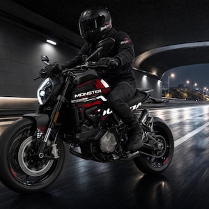 May include: A black Ducati Monster motorcycle with red and white accents on the fuel tank, featuring the text MONSTER. The motorcycle has a prominent LED headlight, black wheels, and a dual exhaust system, ridden by a person in black gear.