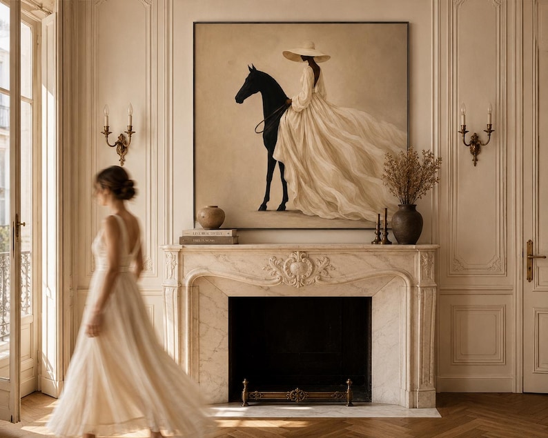 May include: A large square wall art piece featuring a painting of a person in a wide-brimmed hat and a flowing cream-colored gown riding a black horse. The artwork is displayed above a marble fireplace mantel in a room with light-colored walls.