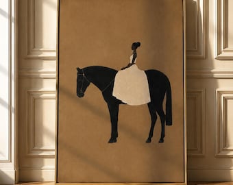May include: A framed wall art print featuring a silhouette of a black horse and a rider wearing a long, light-colored dress. The artwork is set against a solid tan background, and the entire piece is enclosed in a thin, metallic gold frame.