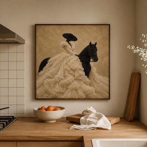 May include: A square framed wall art print featuring a person wearing a wide-brimmed black hat and a voluminous, layered cream-colored ruffled gown, mounted on a black horse against a textured beige background, displayed in a kitchen setting.