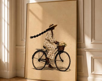 May include: A framed wall art print depicting a person with a long braided hairstyle wearing a wide-brimmed straw hat and a white polka-dot jumpsuit, riding a black bicycle with a wicker basket filled with light-colored flowers on the front.