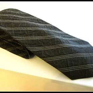 May include: A black and white striped tie with a textured surface.