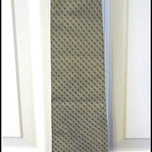 May include: A beige tie with a brown polka dot pattern.