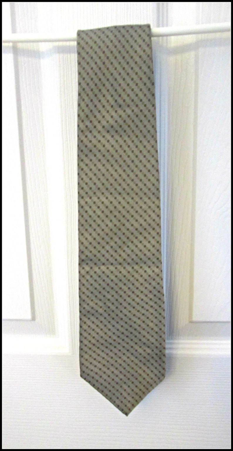 May include: A beige tie with a brown polka dot pattern.