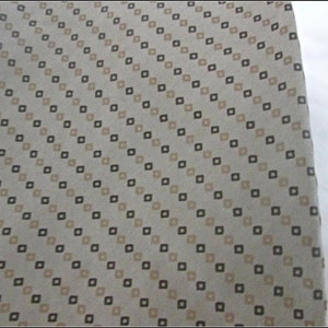 May include: A beige fabric with a diagonal pattern of small brown and beige squares.