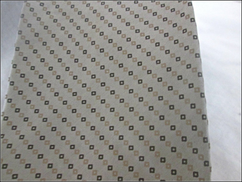 May include: A beige fabric with a diagonal pattern of small brown and beige squares.