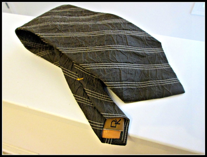 May include: A dark brown striped tie with a brown leather tag that says "DK".