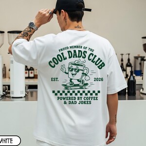 Comfort Colors 1717 White t-shirt on male model featuring a colored Cool Dads Club coffee mug Powered by Coffee graphic, soft unisex fit, garment dyed cotton texture, vintage washed tee for personalized dad gifts, Father's Day shirts, family style.