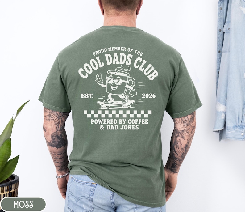 Comfort Colors 1717 Moss t-shirt on male model featuring a white Cool Dads Club coffee mug Powered by Coffee graphic, soft unisex fit, garment dyed cotton texture, vintage washed tee for personalized dad gifts, Father's Day shirts, family style.